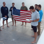 Project Recover team members conduct a flag ceremony to honor the missing service members still associated with the discovered B-25
