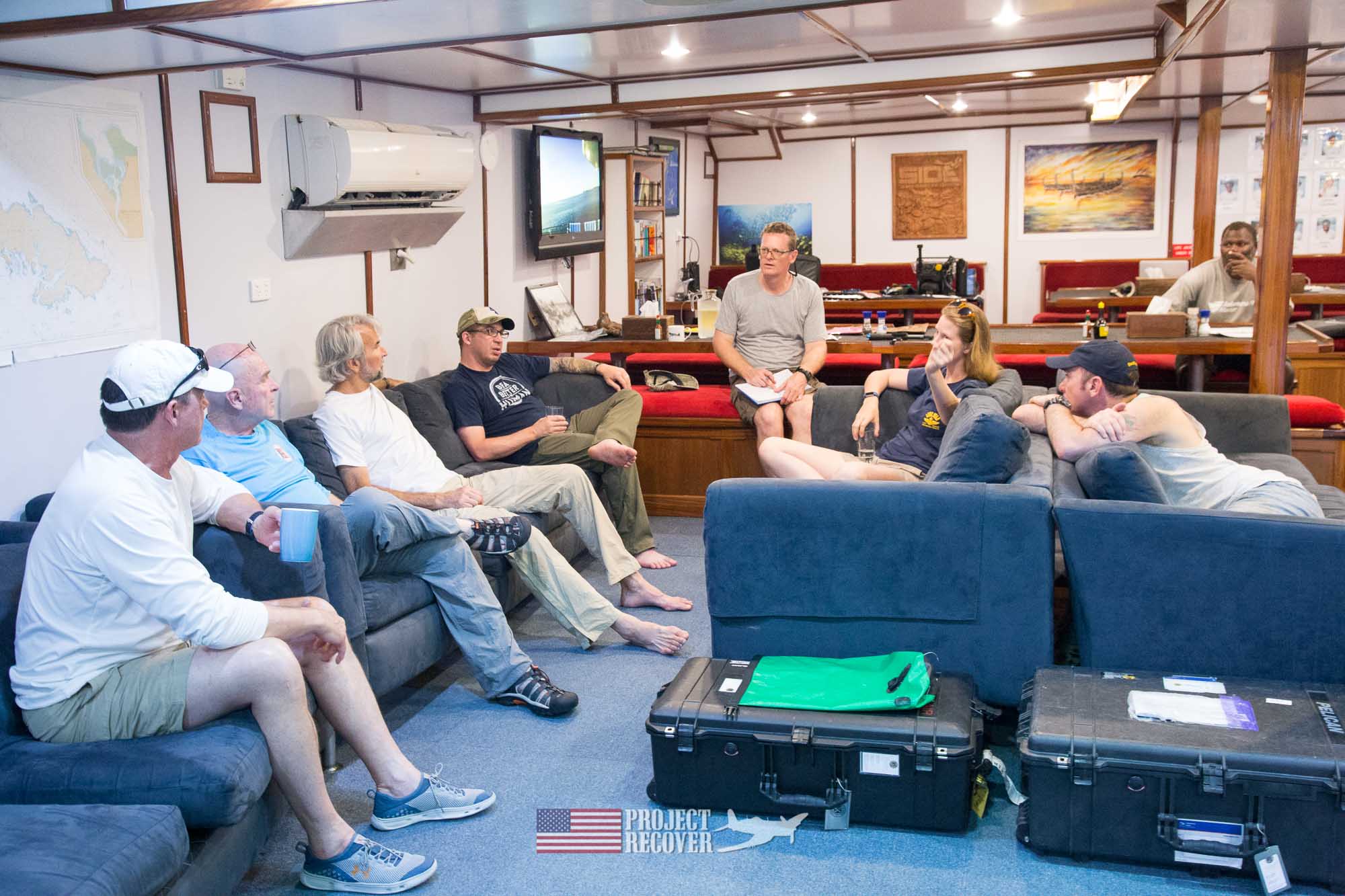 team meeting in the large galley of the Taka Live a Board scuba diving ship - Scuba diving MIA crash sites - Project Recover and BentProp Project are committed to bringing the MIA home. Photos by Harry Parker Photography.com