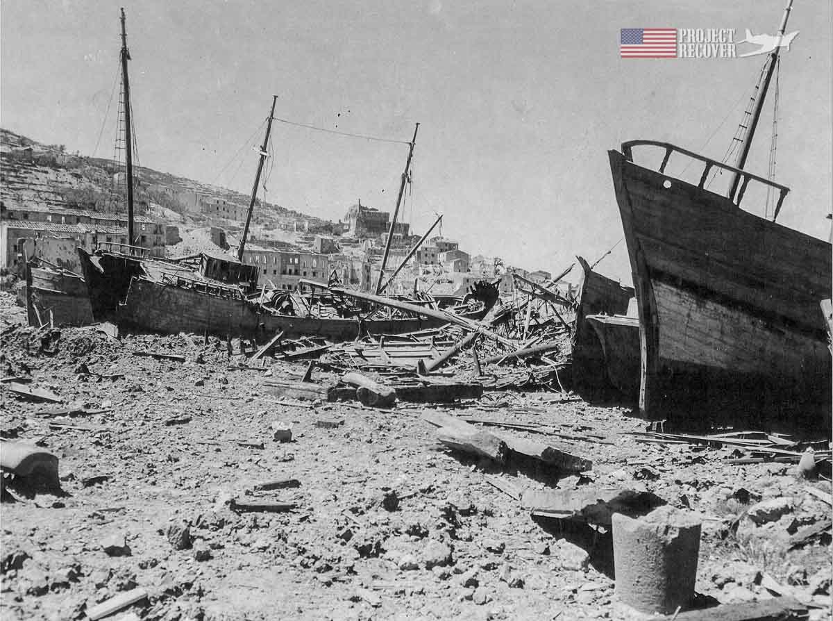 The destroyed shipping port of Porto Santo Stefano, Italy during WWII as Allied Forces fight to remove the Germans. - Project Recover is committed to bringing the MIA’s home