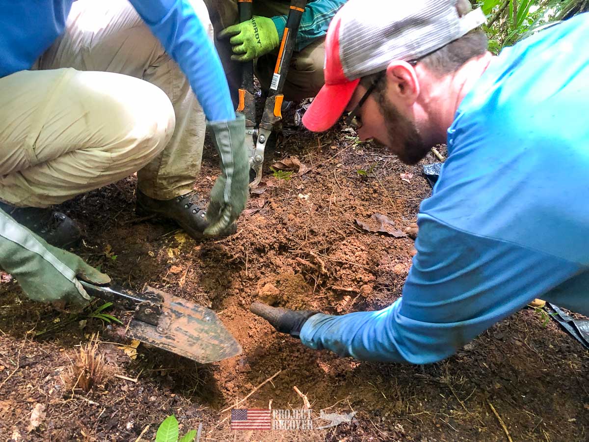 Adam Gray helps with a test pit on a metal detector find in the middle of the Palauan jungle. Our team digs under the supervision of team archaeologist, Jolie Liston, Ph.D. Every artifact is carefully documented. Photo: Harry Parker Photography