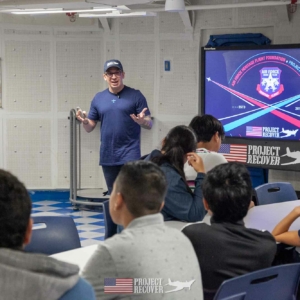 teacher leading students aboard USS Midway