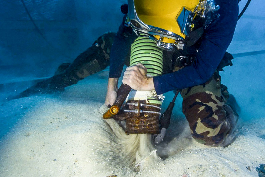 Navy Diver working vacuuming sand underwater during MIA recovery Palau